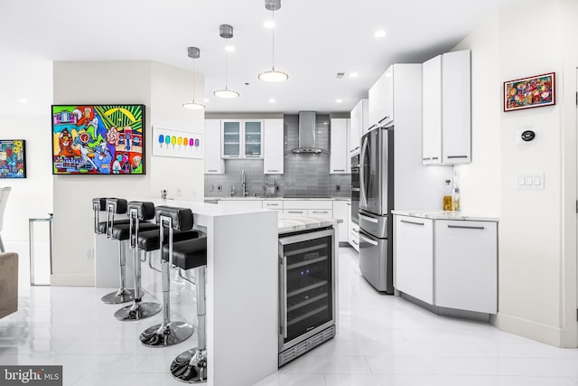100 Harborview Dr Unit 2107, Baltimore, MD 21230 - kitchen featuring beverage cooler, wall chimney exhaust hood, a kitchen bar, freestanding refrigerator, and backsplash