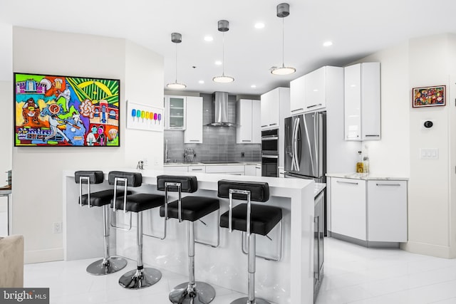 100 Harborview Dr Unit 2107, Baltimore, MD 21230 - kitchen featuring wall chimney range hood, a peninsula, a kitchen bar, stainless steel appliances, and light countertops