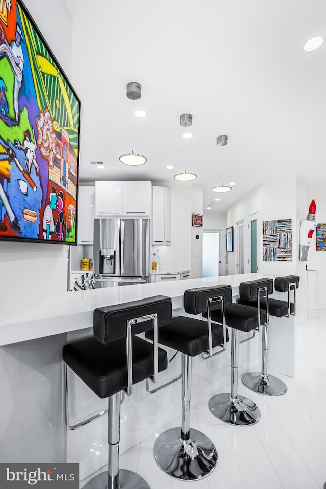 100 Harborview Dr Unit 2107, Baltimore, MD 21230 - kitchen featuring stainless steel refrigerator with ice dispenser, white cabinets, light countertops, light tile patterned floors, and recessed lighting