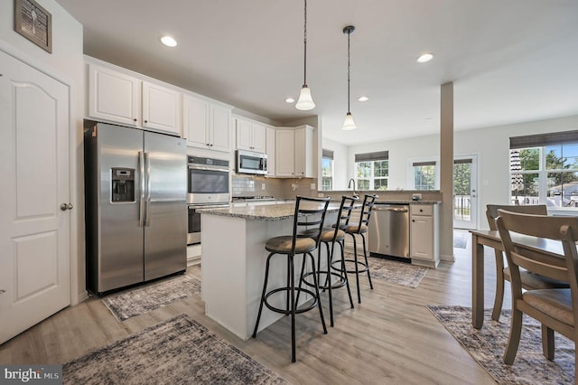 kitchen with a kitchen breakfast bar, light wood-type flooring, visible vents, recessed lighting, and appliances with stainless steel finishes