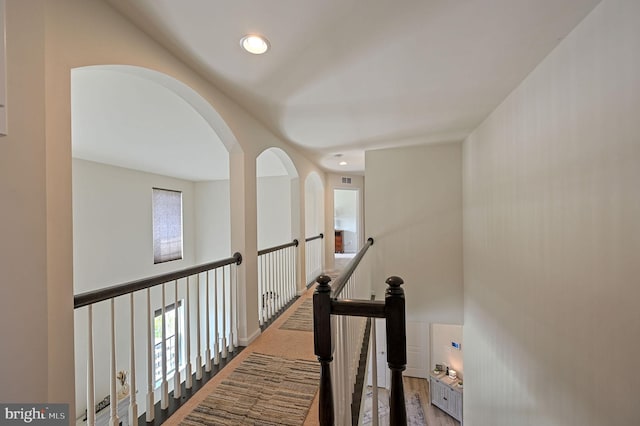 corridor featuring an upstairs landing, recessed lighting, and plenty of natural light