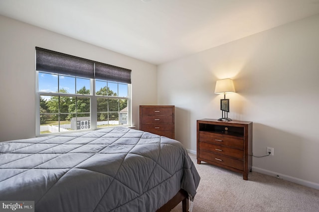 bedroom with light carpet and baseboards