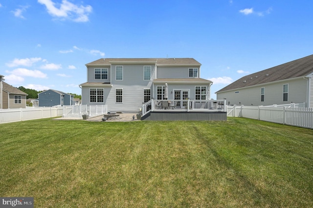 rear view of house with a yard, a deck, a fenced backyard, and a patio