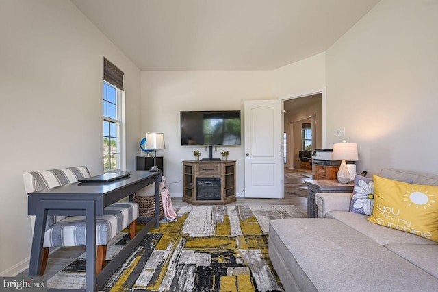 living area with baseboards and wood finished floors