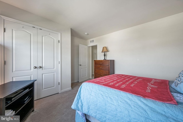 carpeted bedroom with a closet, visible vents, and baseboards