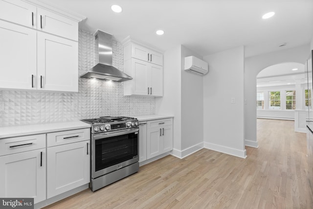 14 Titus Ave, Lawrence, NJ 08648 - kitchen featuring gas stove, wall chimney range hood, arched walkways, a wall mounted AC, and recessed lighting