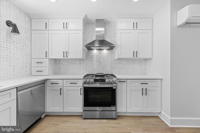 14 Titus Ave, Lawrence, NJ 08648 - kitchen featuring stainless steel gas stove, wall chimney exhaust hood, an AC wall unit, light countertops, and recessed lighting