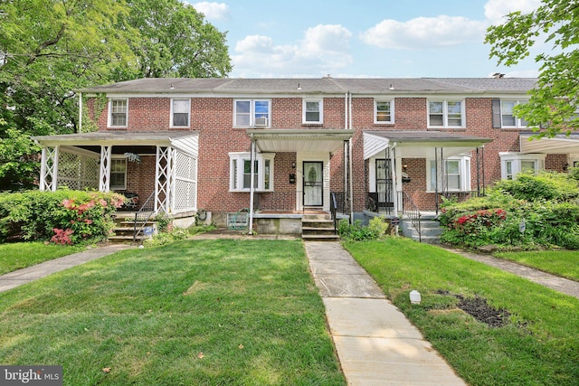view of property with a front yard, brick siding, and a porch