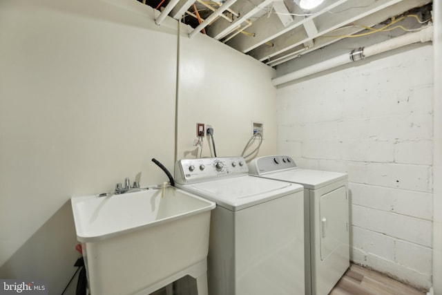 laundry area with independent washer and dryer and concrete block wall