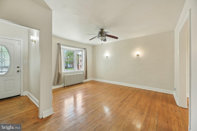 foyer entrance featuring radiator, a ceiling fan, hardwood / wood-style floors, and baseboards