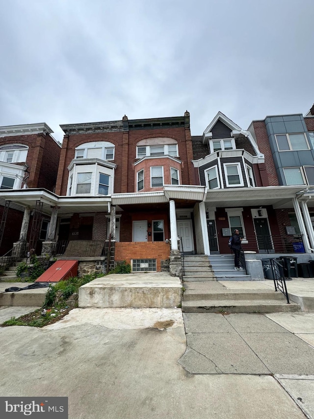 multi unit property with a porch and brick siding