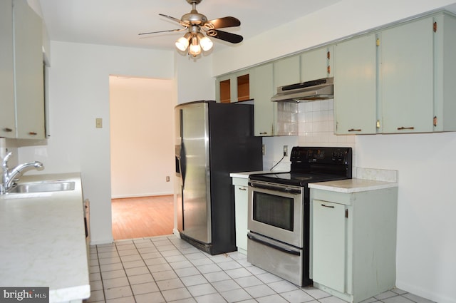 8814 Lafayette Dr, Owings, MD 20736 - kitchen featuring stainless steel appliances, under cabinet range hood, a sink, light countertops, and a ceiling fan