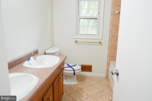 8814 Lafayette Dr, Owings, MD 20736 - full bath featuring tile patterned floors, toilet, a bathtub, baseboards, and double vanity