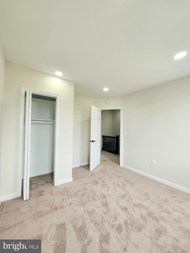 unfurnished bedroom featuring carpet flooring, baseboards, a closet, and recessed lighting