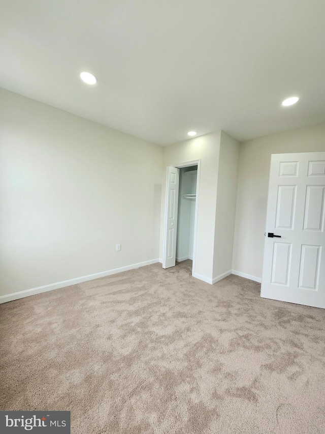 unfurnished bedroom featuring baseboards, a closet, recessed lighting, and carpet floors
