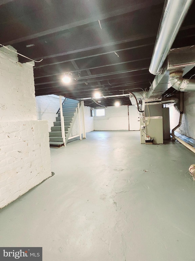 basement featuring heating unit and stairs