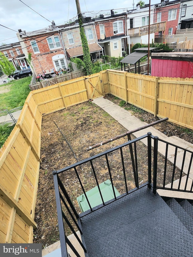 view of yard with a fenced backyard and a gate