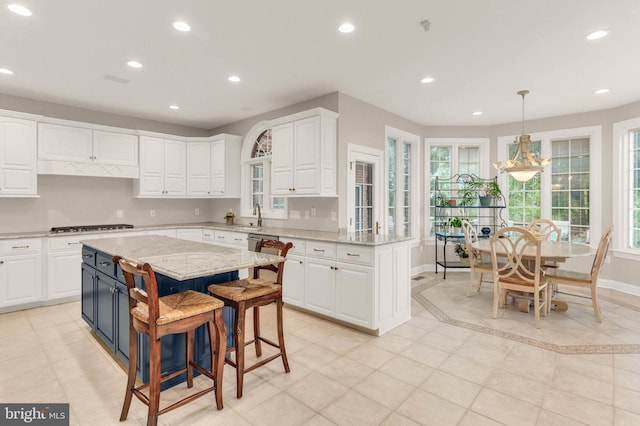13457 Charolais Ct, Highland, MD 20777 - kitchen with white cabinets, recessed lighting, light stone countertops, gas cooktop, and a kitchen breakfast bar