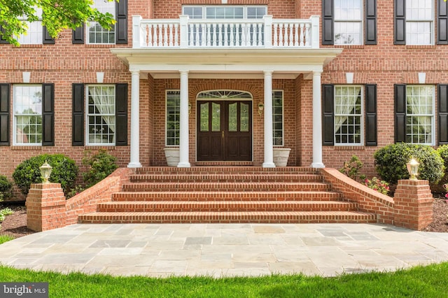 13457 Charolais Ct, Highland, MD 20777 - view of exterior entry with a balcony, brick siding, and a porch