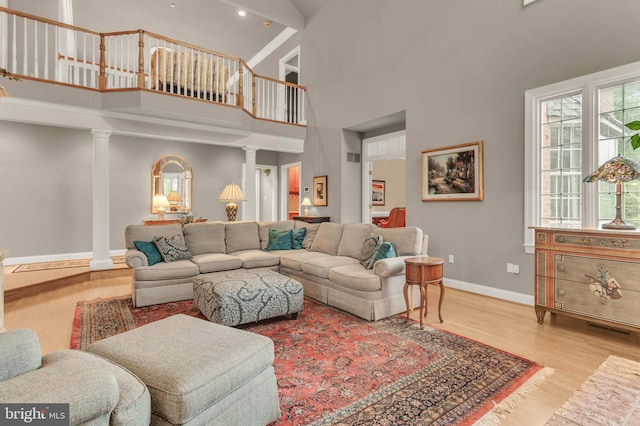 13457 Charolais Ct, Highland, MD 20777 - living room with a high ceiling, wood finished floors, baseboards, and decorative columns