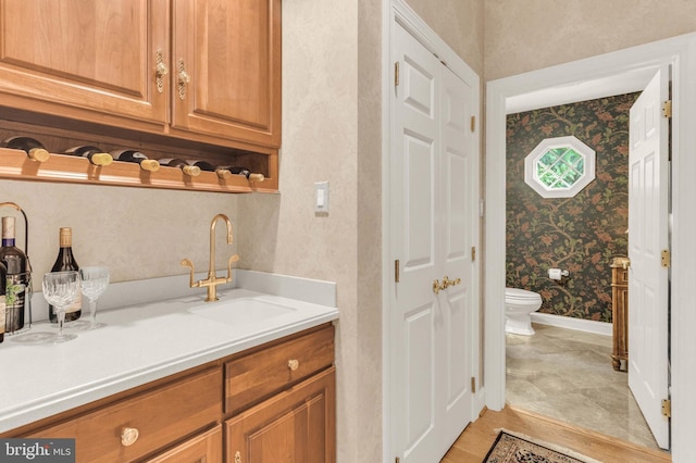 13457 Charolais Ct, Highland, MD 20777 - bar area featuring a sink, wallpapered walls, and baseboards