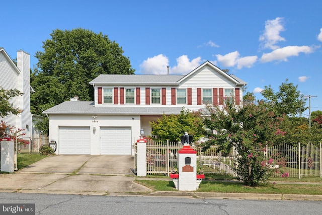traditional-style home featuring concrete driveway, a fenced front yard, roof with shingles, and a garage