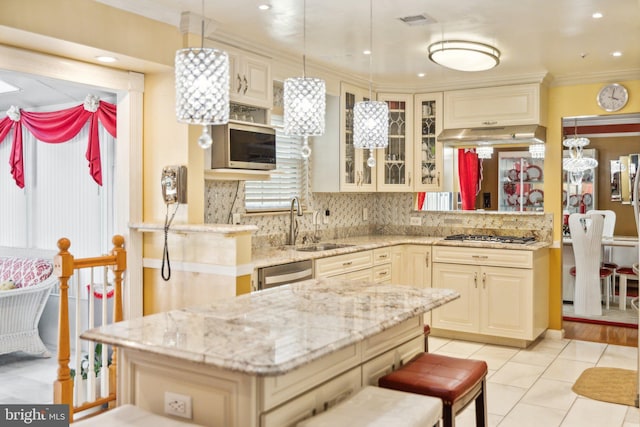 kitchen with light stone counters, stainless steel appliances, decorative backsplash, and a sink