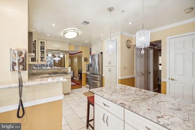 kitchen featuring glass insert cabinets, a kitchen bar, stainless steel fridge with ice dispenser, crown molding, and visible vents