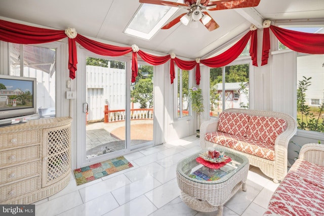 sunroom featuring lofted ceiling with skylight and ceiling fan