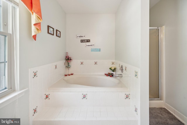 bathroom featuring a shower stall and a bath