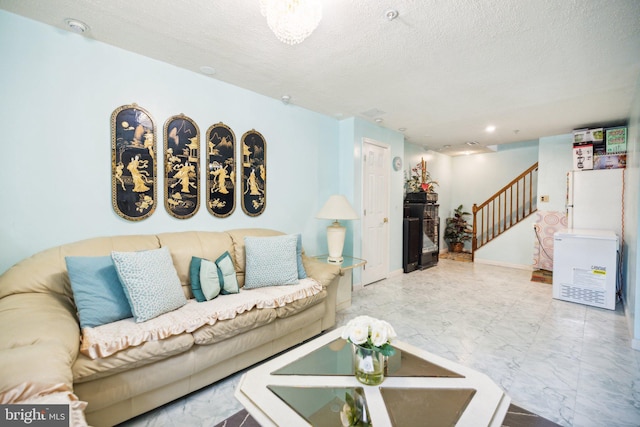 living area with a textured ceiling, stairway, and marble finish floor