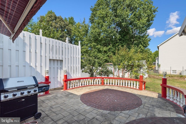 view of patio / terrace with a grill and fence