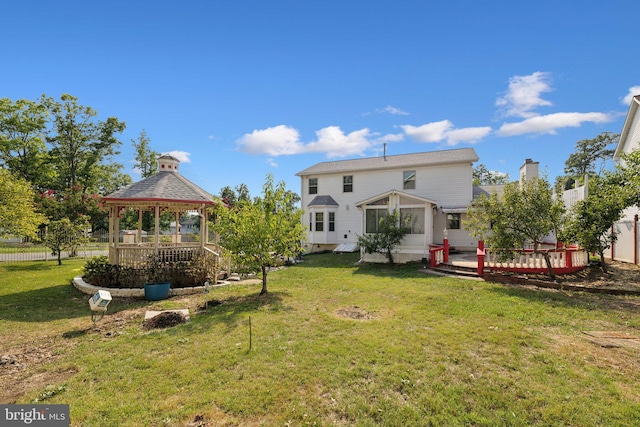 back of house with a lawn, a gazebo, a wooden deck, and fence