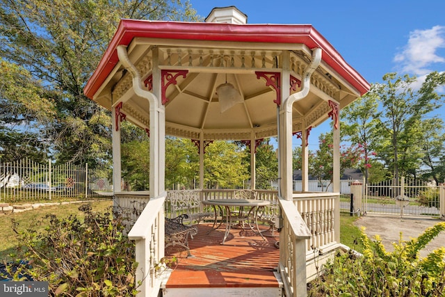 deck featuring outdoor dining area, fence, and a gazebo