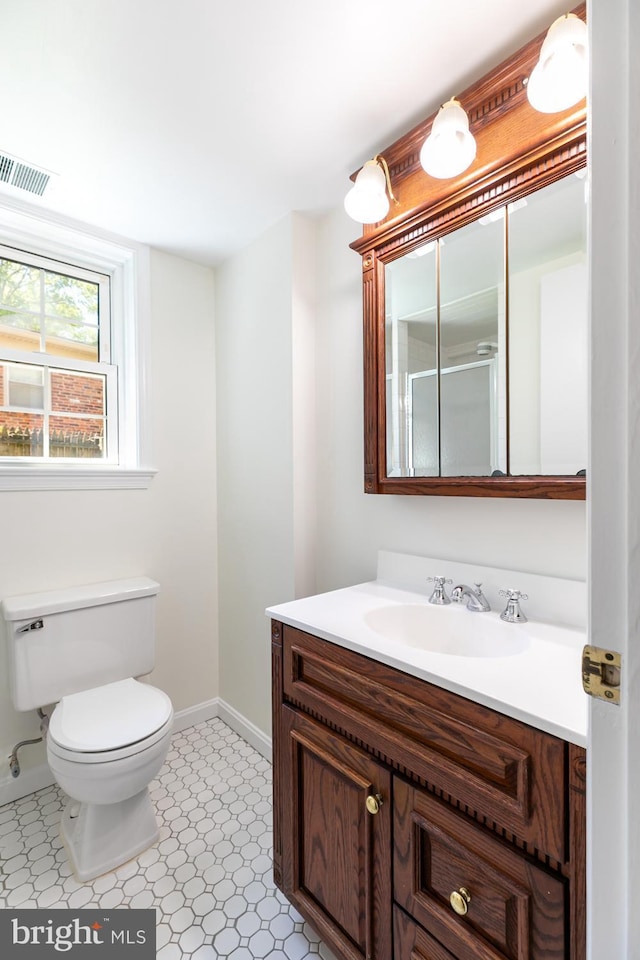 bathroom featuring baseboards, toilet, and vanity