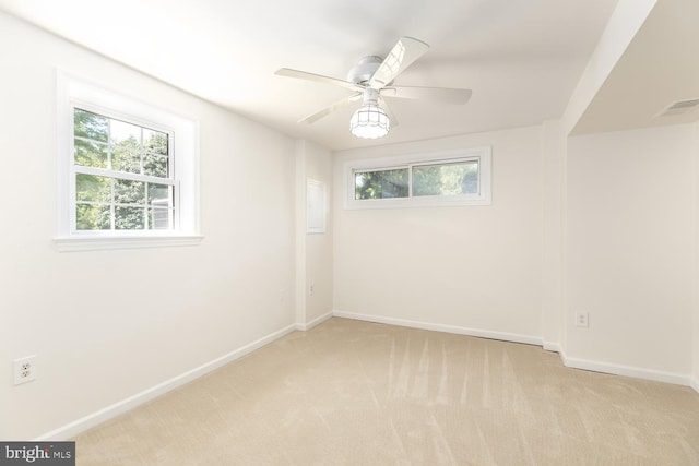 unfurnished room featuring light colored carpet, healthy amount of natural light, and baseboards