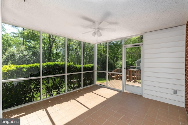 unfurnished sunroom with a ceiling fan and plenty of natural light