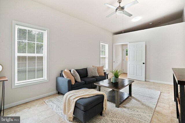 living room featuring ceiling fan, light tile patterned floors, and baseboards