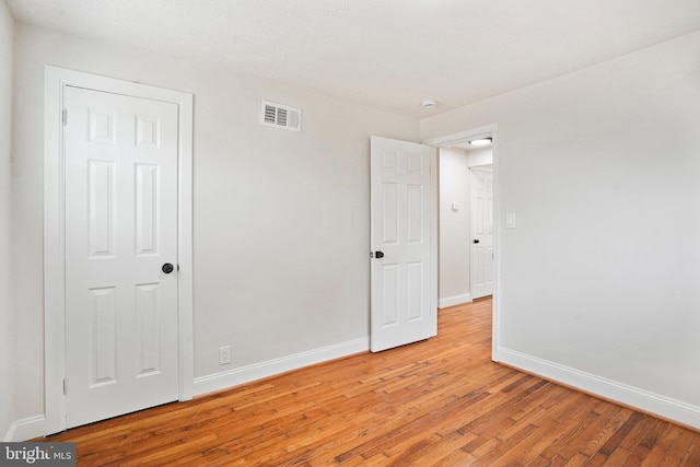unfurnished bedroom with light wood-type flooring and baseboards