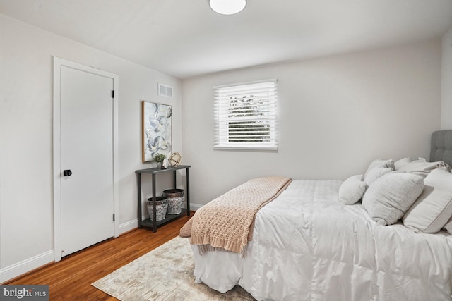 bedroom featuring wood finished floors and baseboards