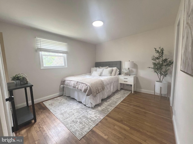 bedroom with baseboards and wood finished floors