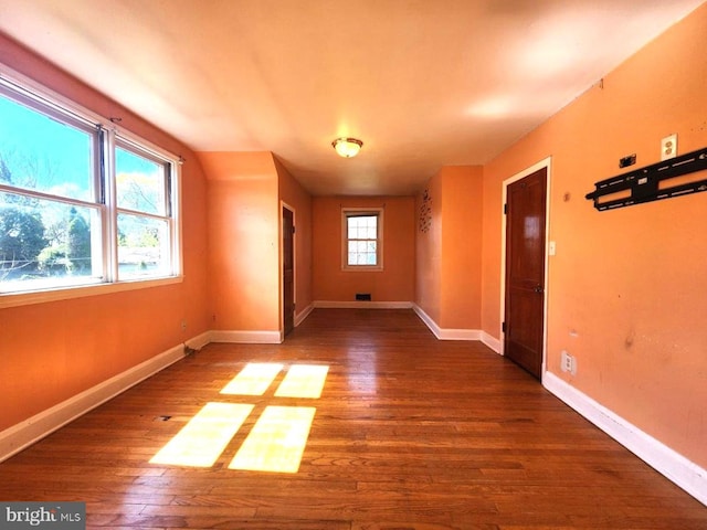 additional living space featuring baseboards and wood-type flooring