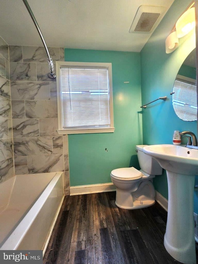 full bathroom featuring baseboards, toilet, visible vents, and wood finished floors