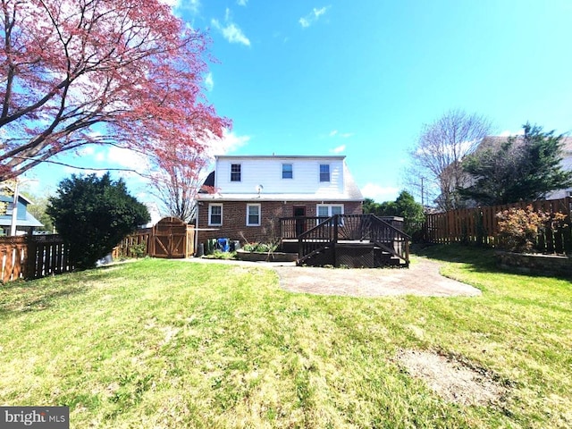 rear view of house with a patio, a gate, a deck, a lawn, and a fenced backyard