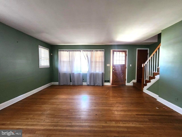 foyer entrance featuring visible vents, wood finished floors, baseboards, and stairs