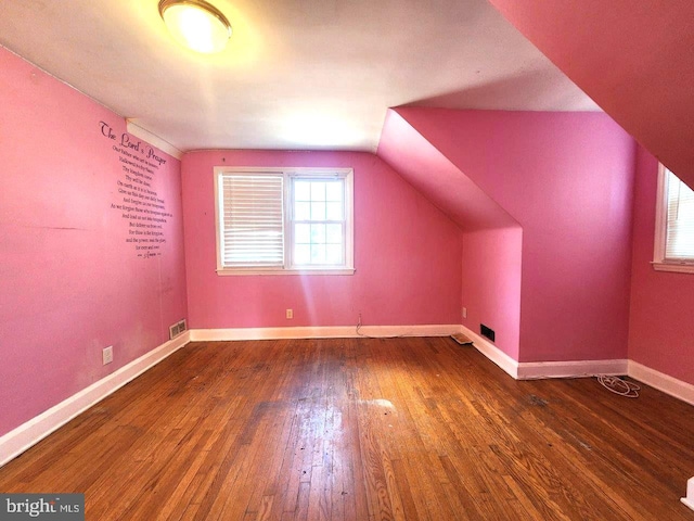 bonus room with vaulted ceiling, baseboards, visible vents, and hardwood / wood-style flooring