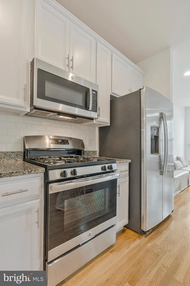 42248 Lancaster Woods Sq, Chantilly, VA 20152 - kitchen with appliances with stainless steel finishes, light wood-style flooring, white cabinets, and decorative backsplash