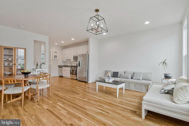 42248 Lancaster Woods Sq, Chantilly, VA 20152 - living area featuring light wood finished floors, a chandelier, and recessed lighting