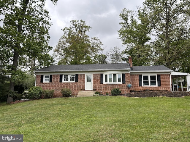 single story home with a chimney, a front yard, and brick siding