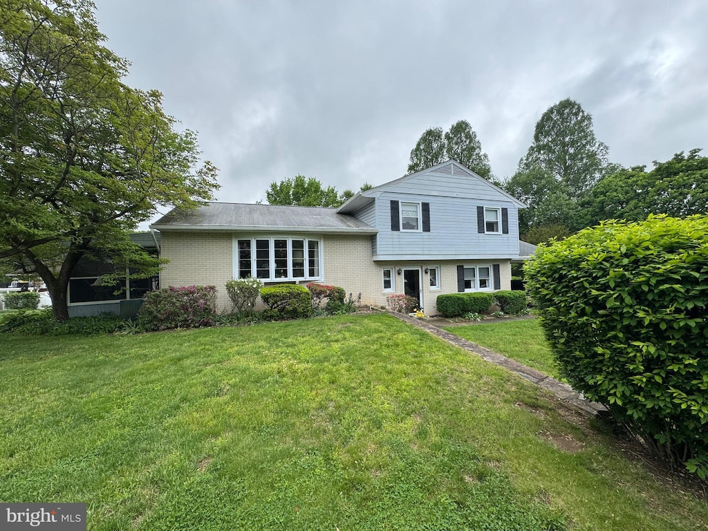 split level home with a front lawn and brick siding